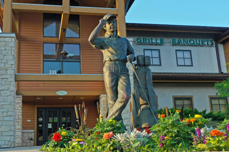 statue of golfer in front of club